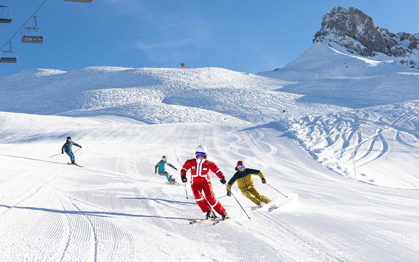 Skilehrer fahren mit einer Gruppe von Leuten den Berg mit den Skiern hinunter